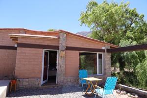 een klein huis met twee blauwe stoelen en een tafel bij Cabañas Los Cardones Tilcara in Tilcara