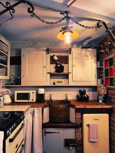 a kitchen with white cabinets and a stove top oven at Rose Cottage in Whitby