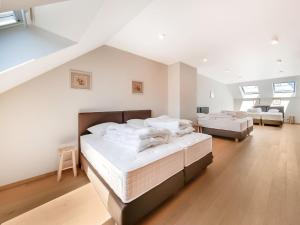 zwei Betten in einem großen Zimmer mit weißen Wänden in der Unterkunft Charming Rural Retreat in Bourseigne-Neuve