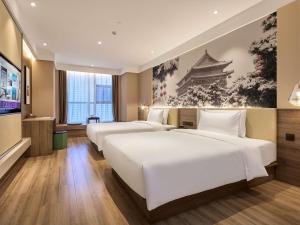 Una habitación de hotel con dos camas y un televisor. en Mercure Xi'an Daming Palace, en Xi'an 92 fotos más