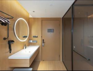 a bathroom with a sink and a mirror at JI Hotel Hangzhou Alibaba Xixi Park in Hangzhou