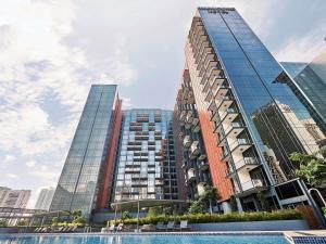 Un edificio alto con una piscina enfrente. en Mercure ICON Singapore City Centre, en Singapur