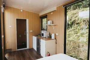 una cocina en una casa pequeña con nevera en Ninekm Forest Wilderness X by Tiny Away, en Wufeng