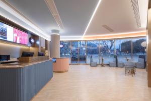 a lobby with a waiting area with tables and chairs at Hanting Hotel Nanjing Hexi Wanda in Nanjing