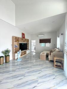 a living room with a couch and a tv at Private home in Chiang Mai +18 photos