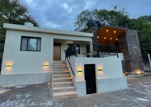 Una casa blanca con escaleras al frente. en Rent House, en El Rodeo