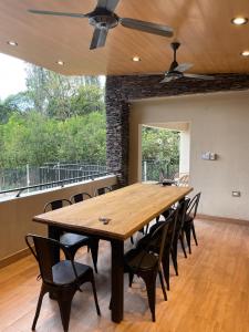 Un comedor con una gran mesa y sillas de madera. en Rent House, en El Rodeo