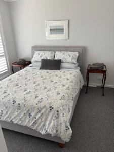 Bundanoon Rochester Guest House في بوندانون: غرفة نوم بسرير وطاولة مع نافذة +صورتان