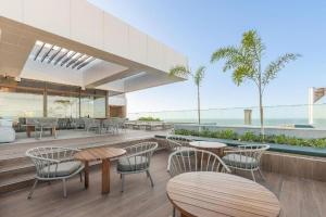 a restaurant with tables and chairs and a view of the ocean at Studio beach class Meireles in Fortaleza