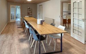 a large wooden table with chairs in a room at 5 Bedroom Awesome Home In Lemvig in Nørby