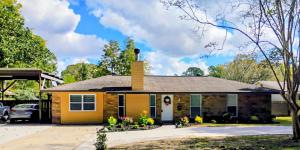 The Denham Springs Esape- Pool, Comfort & Charm في دينهام سبرينغز: منزل أصفر مع مدخنة في الأعلى