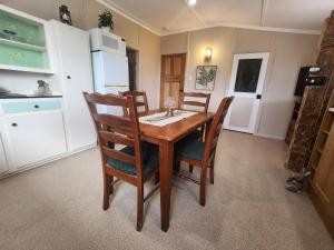 Jack's Shack Kingscote في كنغزكوت: مطبخ مع طاولة وكراسي خشبية