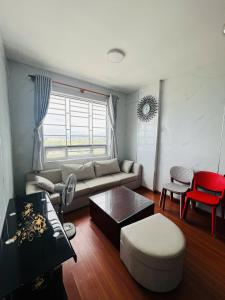 a living room with a couch and a table at Tom coffee and home stay in Thôn Mỹ Phước