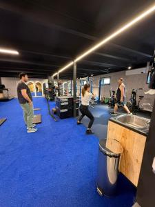 a group of people in a gym with blue carpet at Casa Taller Meular Chiloé in Castro