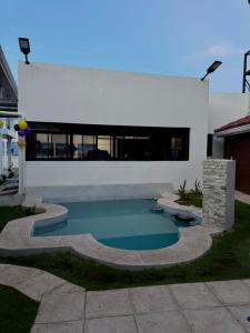 a swimming pool in front of a house at Hostal Boutique Isabel in Managua