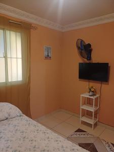 um quarto com uma cama e uma TV de tela plana em Dona Beba Guesthouse em La Caleta