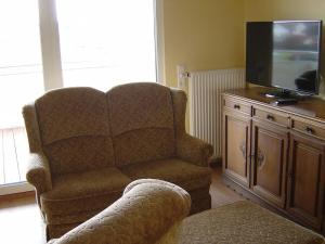 ein Wohnzimmer mit einem Stuhl und einem Flachbild-TV in der Unterkunft Holiday apartment with 2 bedrooms in Sasbach am Kaiserstuhl