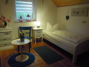 een kleine slaapkamer met een bed en een tafel bij Holiday home at Fleesensee in Silz