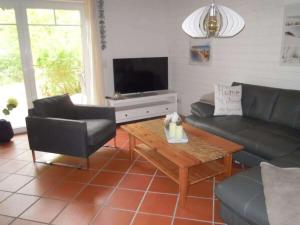 een woonkamer met een bank en een tafel bij Holiday home at Fleesensee in Silz