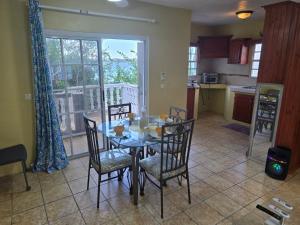 a dining room with a table and chairs in a kitchen at Beach Front Apartment & Car Rental in Baie Nettle