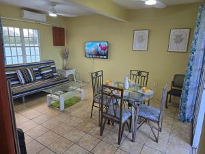a living room with a table and chairs and a couch at Beach Front Apartment & Car Rental in Baie Nettle