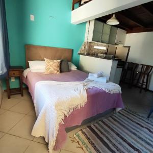 ein Schlafzimmer mit einem Bett mit einer lila Decke in der Unterkunft Pousada Sereia Morena in Florianópolis
