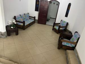 a living room with two chairs and a door at Casa da Sol in Arraial do Cabo