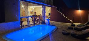 een groot blauw bad in een kamer met een bar bij Chalé Viçosinha de Açúcar in Viçosa do Ceará