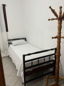 a bedroom with a bed and a wooden pole at Casa da Sol in Arraial do Cabo +14 photos