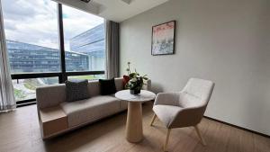 a living room with a couch and a chair and a table at Also Hotel in Shanghai
