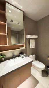 un bagno con lavandino, WC e specchio di Also Hotel a Shanghai