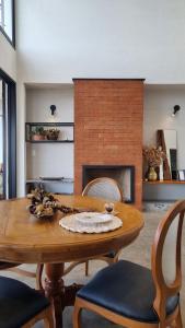 a dining room with a table and a fireplace at Casa La Vigie in Águas de Lindoia