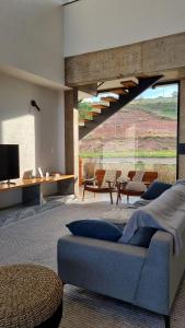a living room with a blue couch and a tv at Casa La Vigie in Águas de Lindoia