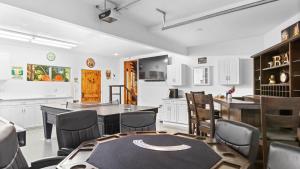 a kitchen with white cabinets and a table and chairs at The Fairway Hideaway by AvantStay Game Room Outdoor Dining Near Lake Arrowhead in Lake Arrowhead