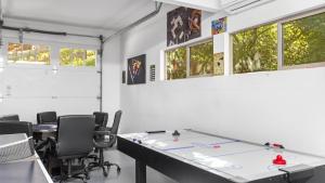 a room with a ping pong table and chairs at The Fairway Hideaway by AvantStay Game Room Outdoor Dining Near Lake Arrowhead in Lake Arrowhead