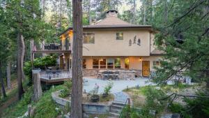 a large house in the middle of a forest at The Fairway Hideaway by AvantStay Game Room Outdoor Dining Near Lake Arrowhead in Lake Arrowhead