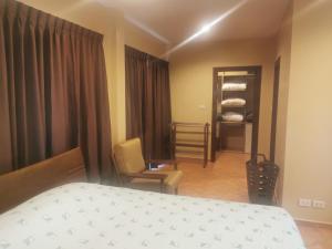 a bedroom with a bed and a chair in a room at Ben's House Bangsaen in Bangsaen