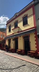 un bâtiment avec des tables et des chaises dans une rue dans l'établissement Pousada Elite, à Santa Teresa