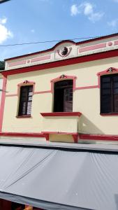 un bâtiment avec deux fenêtres et un auvent blanc dans l'établissement Pousada Elite, à Santa Teresa