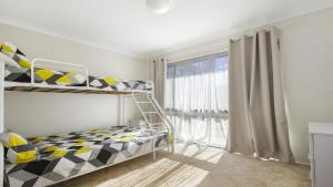 een slaapkamer met een stapelbed en een raam bij Beachway in Orient Point