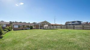 een tuin met een hek en een huis bij Beachway in Orient Point
