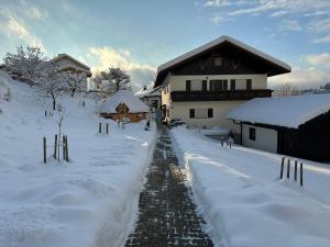 a snow covered path in front of a house at Haus Monica in Bodenmais
