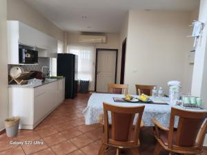 a kitchen with a table and chairs in a room at Ben's House Bangsaen in Bangsaen
