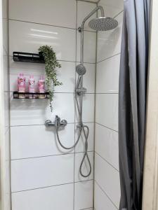 een douche in een wit betegelde badkamer bij HouseofGeneration in Stuttgart