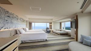 a hotel room with a bed and a television at Phoenix Seagaia Ocean Tower in Miyazaki