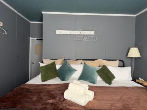 a bedroom with a large bed with green and blue pillows at Rusutsu Ski Stay111 in Rusutsu +68 photos