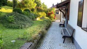two benches sitting on a brick walkway next to a building at Haus Monica in Bodenmais