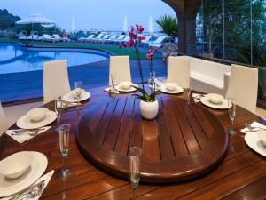 uma mesa de madeira com pratos e taças de vinho sobre ela em Villa in Ibiza with Sea Views and Jacuzzi em Sant Jordi