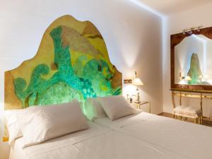um quarto com uma cama branca e uma pintura na parede em Villa in Ibiza with Sea Views and Jacuzzi em Sant Jordi mais 32 fotografias