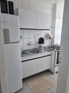 a white kitchen with a sink and a stove at Bem vindo ao APTO 403 in Florianópolis